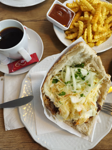 Gyros im Fladenbrot mit reichlich Krautsalat, daneben Pommes mit Ketchup und ein Espresso